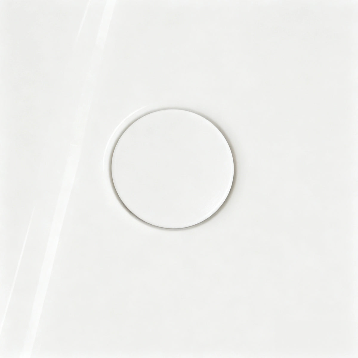 Close-up of the color-matched drain in the glossy white bathtub.