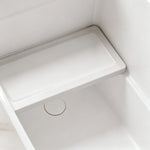 Interior seat and drain detail inside the glossy white compact bathtub.