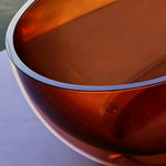Close-up of the clear-edged rim and transparent brown bathtub wall.