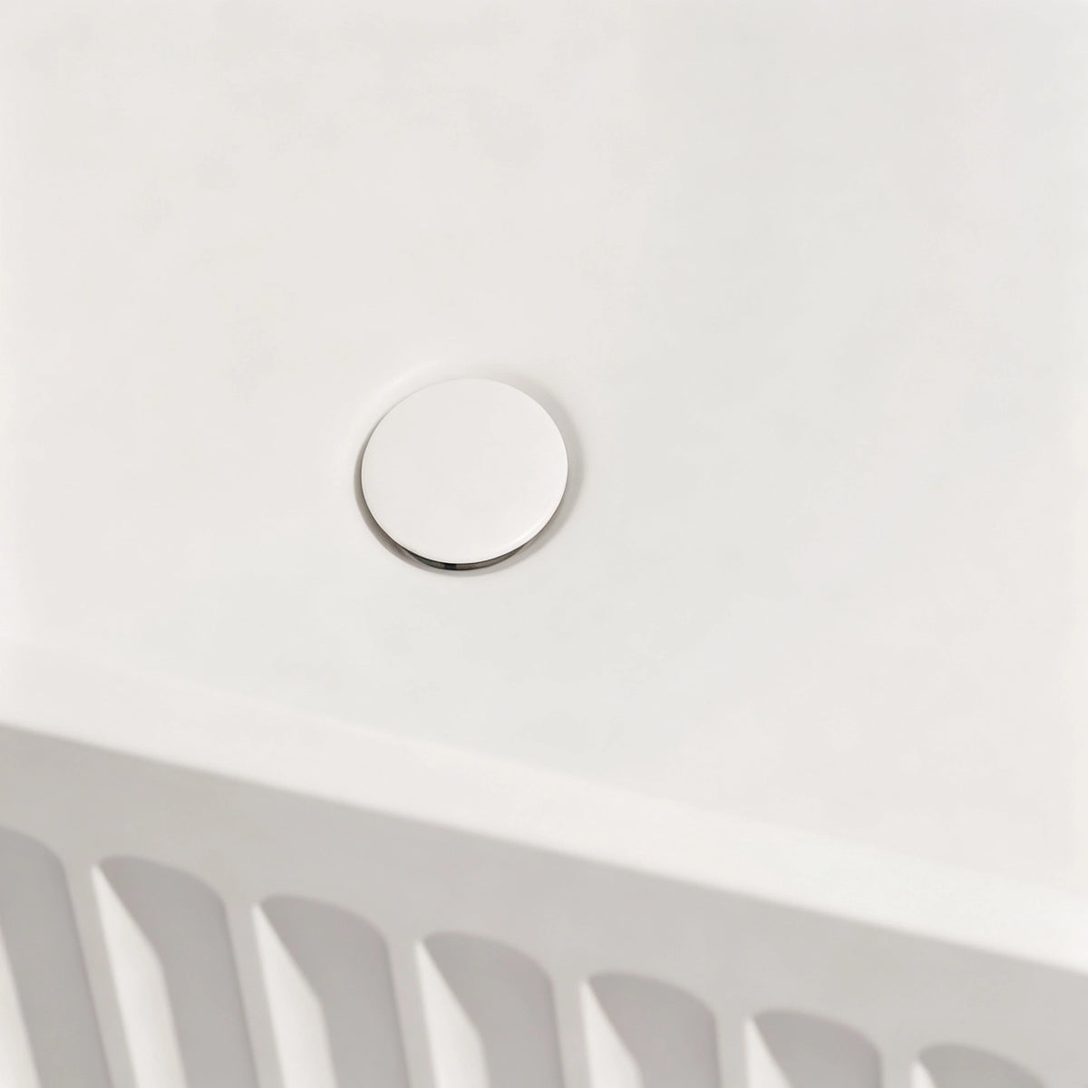 Close-up of the color-matched drain inside the fluted bathtub.