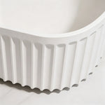Close-up of the rounded corner and vertical fluting on the bathtub exterior.