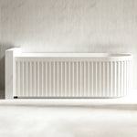 Front view of the curved fluted panel on the glossy white bathtub.
