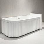 Side-angle view of the curved-front fluted back-to-wall bathtub.