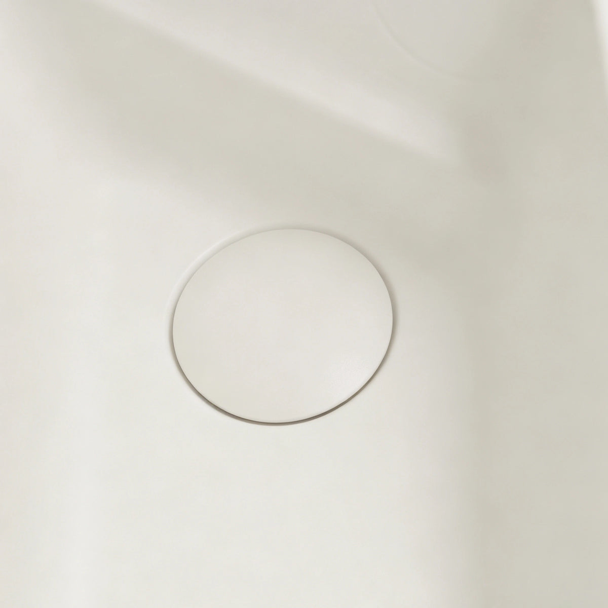 Close-up of the color-matched drain inside the rectangular fluted bathtub.