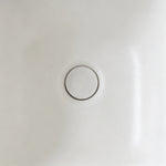 Close-up of the color-matched drain inside the ribbed back-to-wall bathtub.