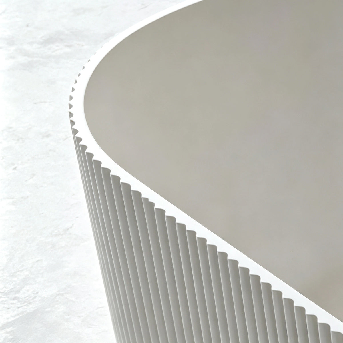 Close-up of the curved basin, narrow rim and slot overflow.