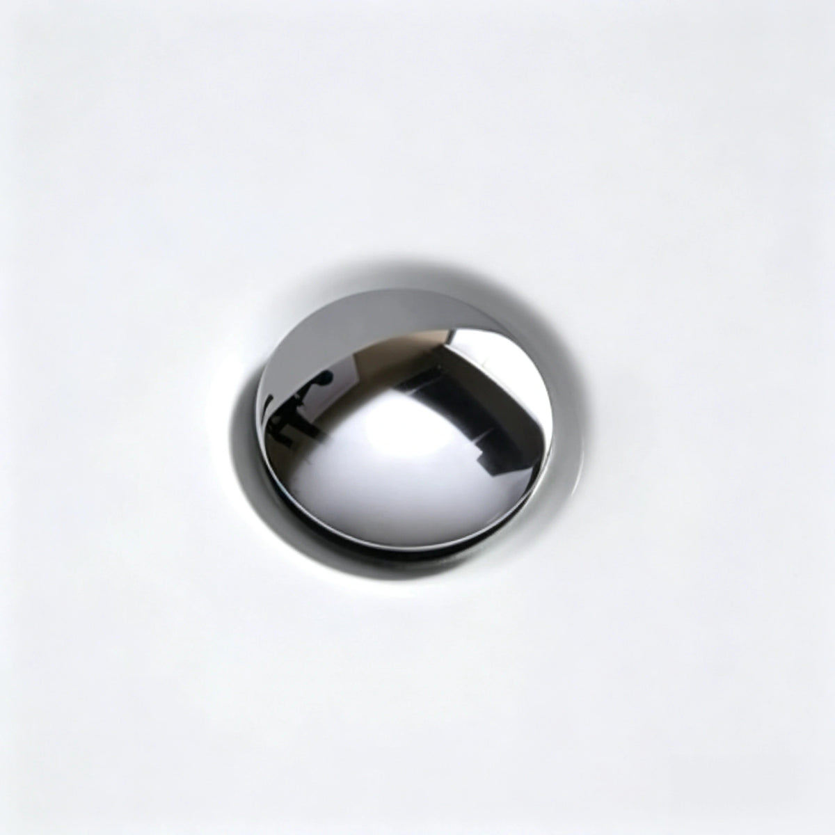 Close-up of the chrome drain inside the acrylic bathtub.