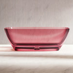 Front view of the transparent pink freestanding bathtub and sculpted base.