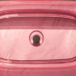 Close-up of the dark overflow fitting inside the pink resin bathtub.