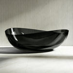 Front bathroom view of the transparent black sculptural bathtub.