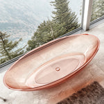 Top view into the transparent pink oval bathtub basin.