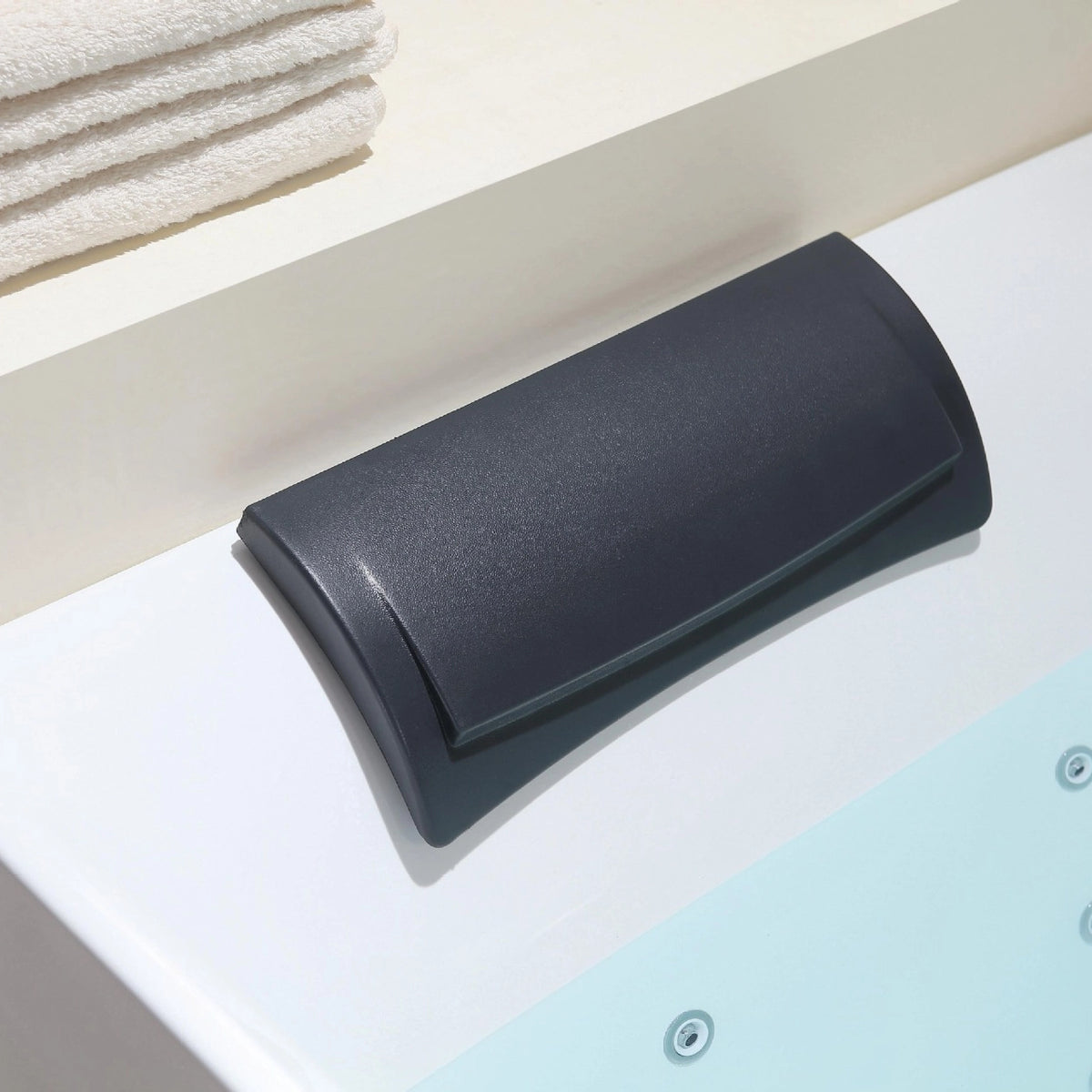 Close-up of soft black bathtub pillow matched with rectangular soaking tub