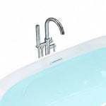 Close-up of chrome floor faucet and tub overflow trim on white bath rim
