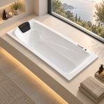 Drop-in bathtub with pillow built in sunlit bathroom with coastal scenery