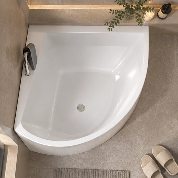 Top-down shot of corner bathtub in bright tiled bathroom