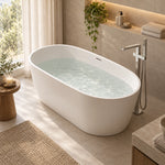 Oval white soaking tub beside sheer curtain and large window in bright washroom