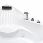 Close-up of waterfall spout, hand shower and control knobs on tub rim