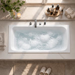 Top view of rectangular built-in tub with bath accessories on stone countertop