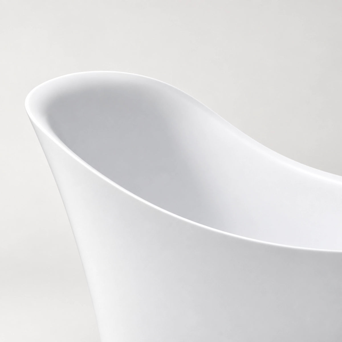 Close‑up shot of curved sloped rim of white acrylic bathtub