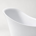 Close‑up shot of curved sloped rim of white acrylic bathtub