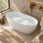 White oval freestanding bathtub in a home bathroom next to window and wall niche