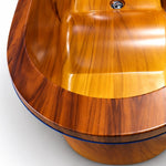 Close-up of bathtub rim, smooth wood-grain tub surface with blue trim line and built-in drain