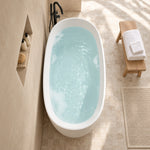 Top view of oval freestanding bathtub inside light beige tiled bathroom with recessed shower niche
