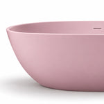 Close-up of matte pink bathtub rim, showing seamless wall and built-in overflow