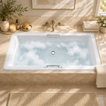 Rectangular drop-in tub in bright bathroom, equipped with wall-mounted faucet, towels and decorative ornaments