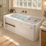 One-piece bathtub with metal grab bars, set in residential bathroom with textured glass window beside stone countertop