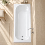 Top view drop-in bathtub in spacious bathroom with beige woven bath mat, towels and green plant decor