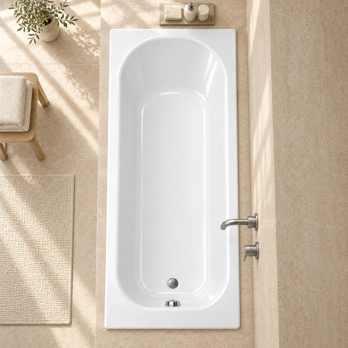 Top view drop-in bathtub in spacious bathroom with beige woven bath mat, towels and green plant decor