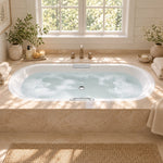 Drop-in oval acrylic bathtub installed on stone deck bathroom with large window and bath accessories, showing real bathing space