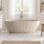 Freestanding textured oval bathtub, placed in bright bathroom with large window and marble floor