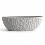 Freestanding soaking bathtub in gray, exterior with flowing sculpted raised texture