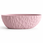Oval freestanding bathtub in soft pink matte, exterior with dimensional twisted relief pattern