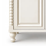 Close‑up of beaded column and carved cabinet leg