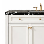 Black marble countertop paired with white cabinetry and gold knobs