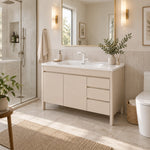 Cream freestanding vanity in light neutral bathroom with glass shower