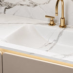 Close‑up of marble sink and brushed gold faucet set