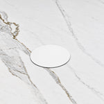 Detail shot of circular white drain cover on marble top