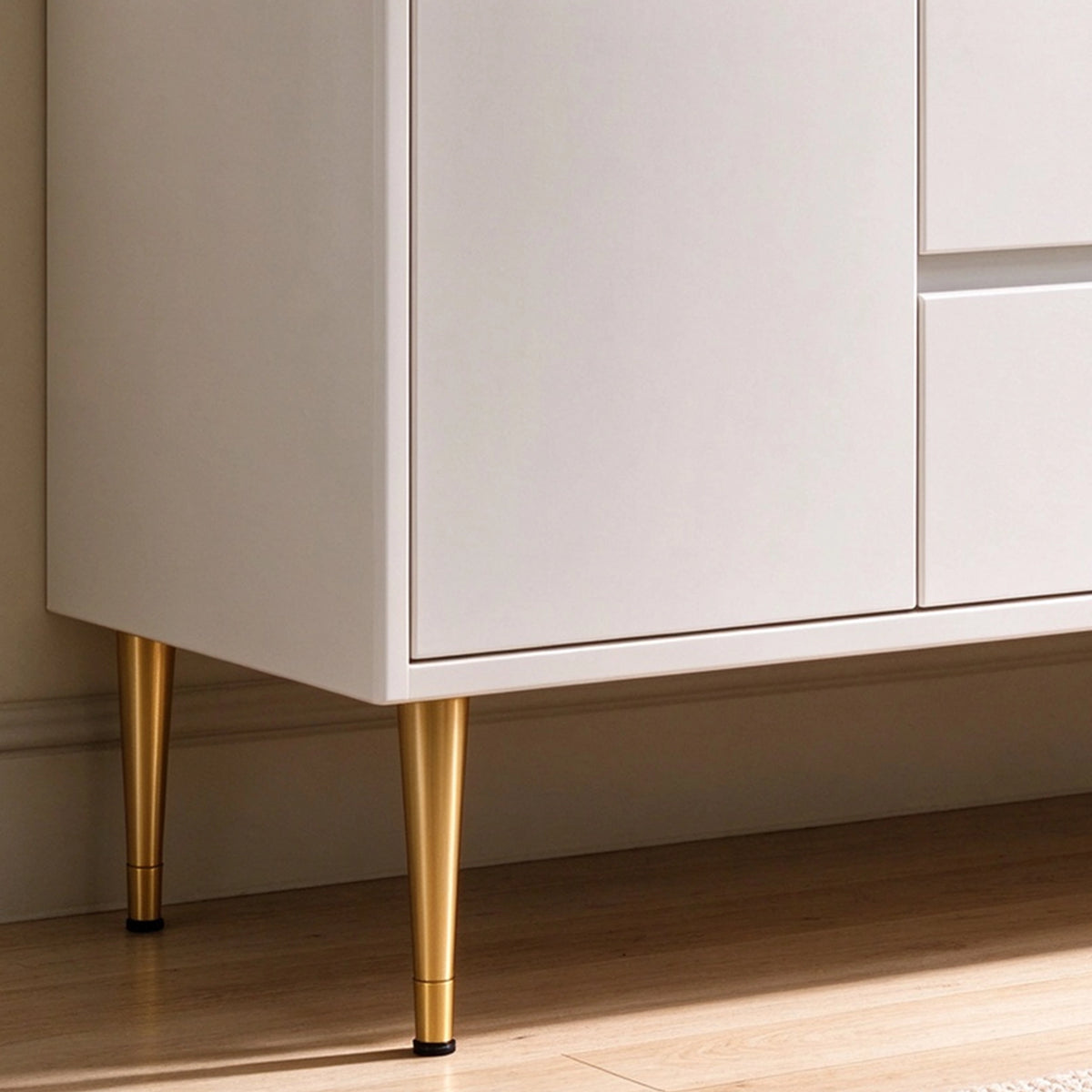 Vanity leg close‑up, white cabinet with tapered gold metal legs