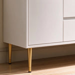 Vanity leg close‑up, white cabinet with tapered gold metal legs