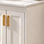 Vanity cabinet door close‑up, white raised‑panel door with long gold pulls
