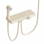 Close‑up of cream thermostatic shower valve shelf, sprayer & hose connection