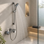 Gunmetal handheld shower spraying water inside glass shower room with niche