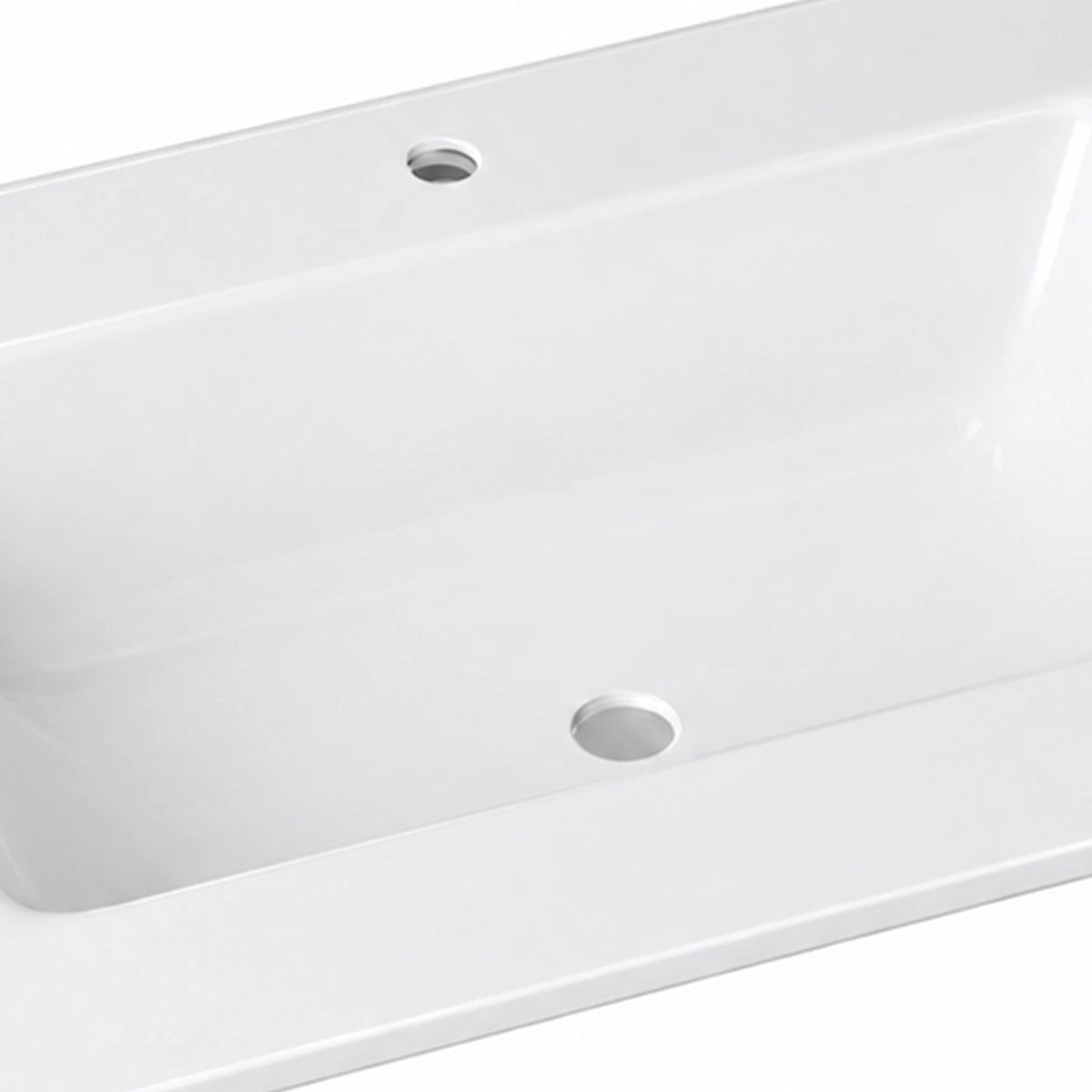 Close-up detail of glossy white ceramic vanity sink, showing basin and overflow hole