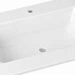 Close-up detail of glossy white ceramic vanity sink, showing basin and overflow hole
