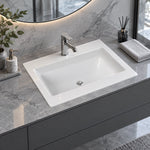 Close view of white ceramic drop-in vanity sink on marble bathroom countertop