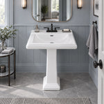 Elegant white ceramic pedestal sink in stylish blue-grey wainscoted bathroom